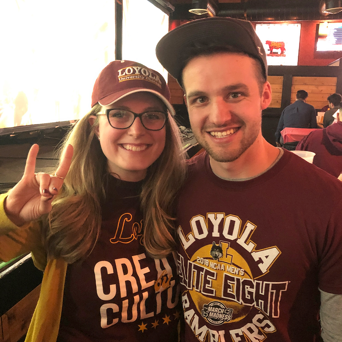 Photo of alumni Anna and Dan Ziemniak in Loyola Athletics tee shirts and caps