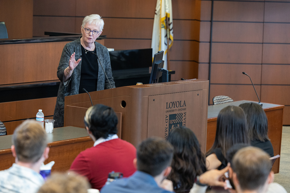 Chief Justice Theis speaks at a lectern in front of first year law students