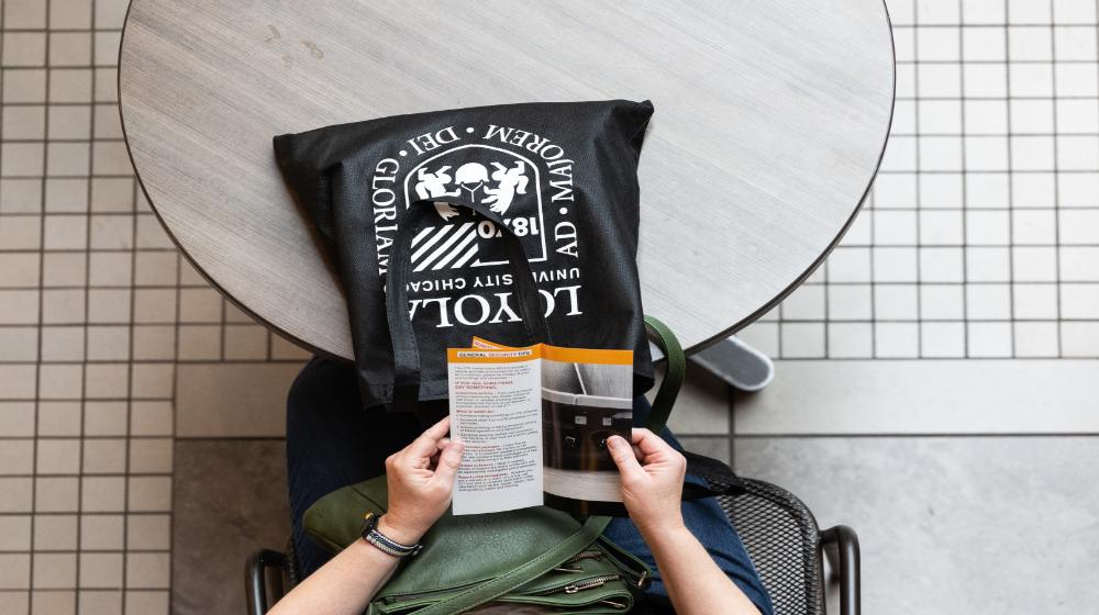 Overhead image of a person holding a brochure via Loyola University Chicago's financial student resources.