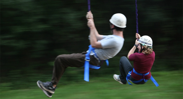 Two people go on a zip line