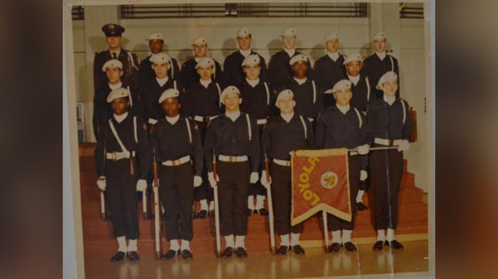 A group photo of Loyola University Chicago ROTC students in uniform. One is holding the ROTC flag