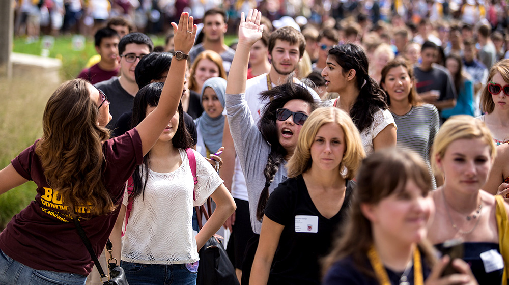 Student high-fiving during new student convocation walk