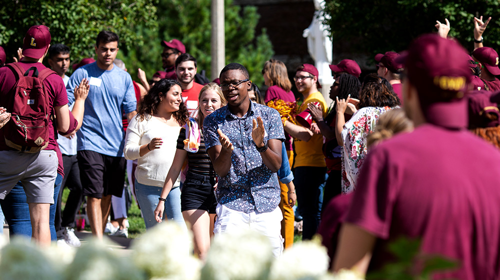 A student clapping their hands during new student convocation walk