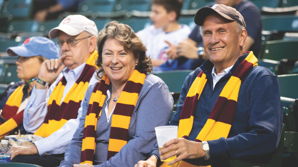 Man and woman with scarves sitting in stadium seats