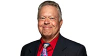 George Senick in a suit on a white background