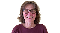 Susan Ries in a maroon sweater on a white background