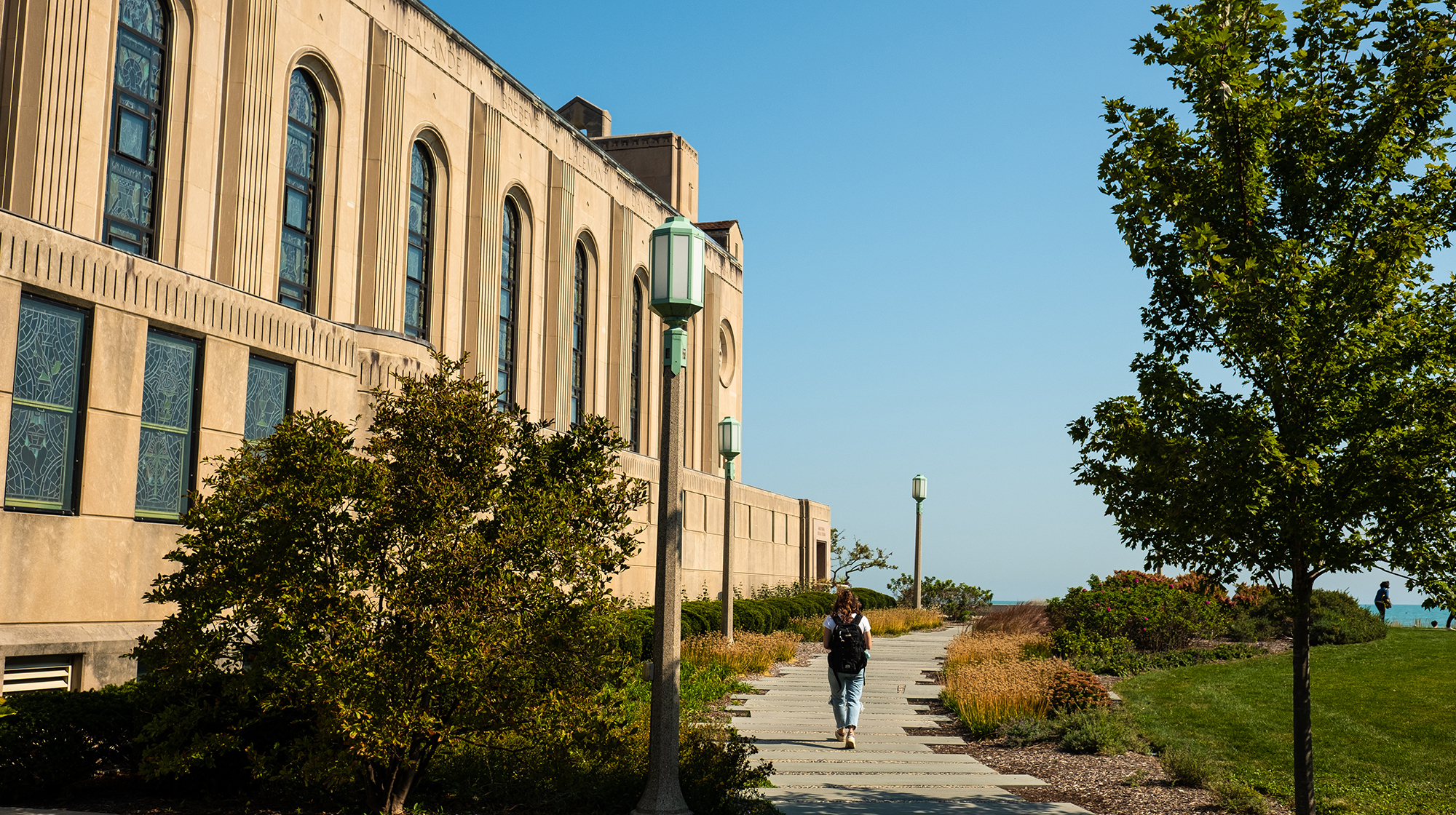 A student goes for a walk on campus by the lake