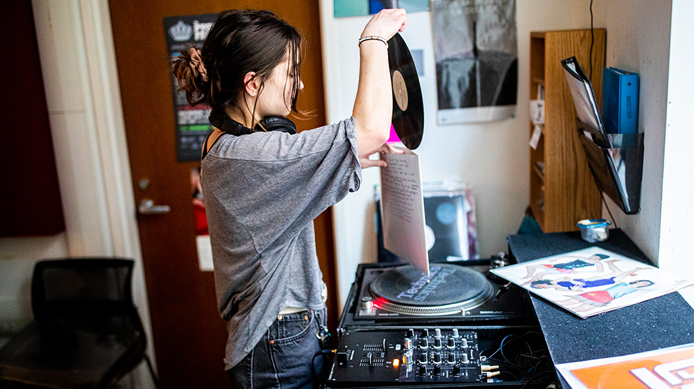 A Loyola University Chicago School of Communications student works in the WLUW studio in the Baumhart Center