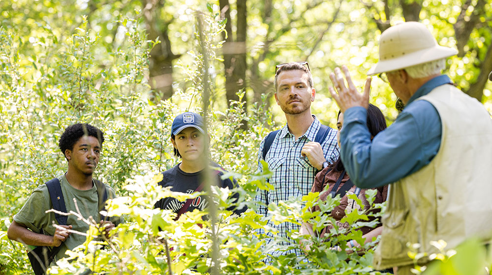 Mark Mackey and students talking with a naturalists during a field trip 