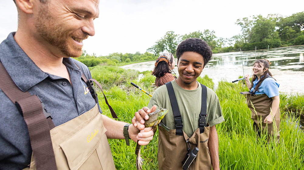 Mark Mackey showing a student a large bullfrog